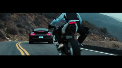 a man riding a motorcycle next to a car on a road