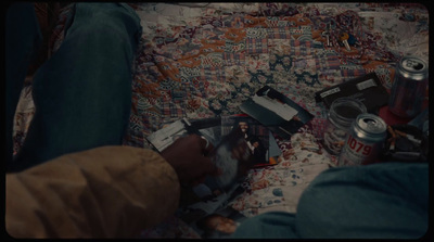 a person laying on a couch with a book and a can of soda