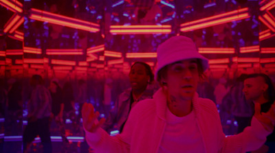 a group of people standing in a room with neon lights