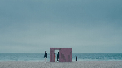 a group of people standing on top of a sandy beach