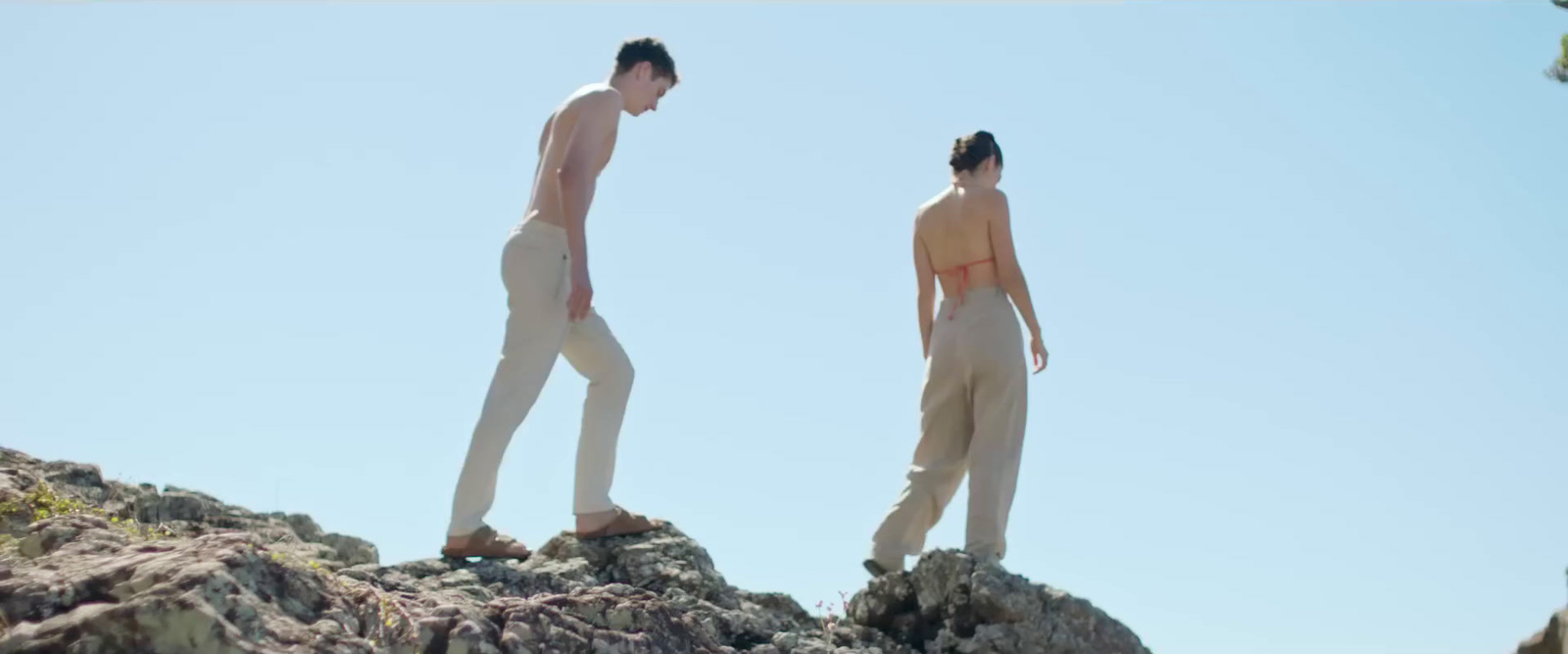 a couple of people standing on top of a rocky hill