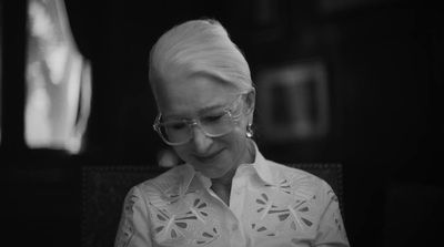 a woman wearing glasses looking at her cell phone