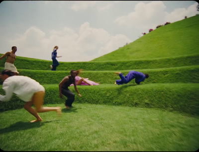 a group of people climbing a grassy hill