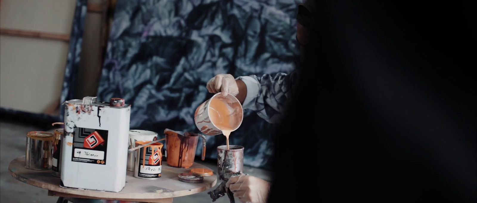 a person pouring something into a cup on a table