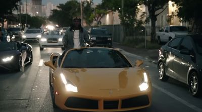 a yellow sports car driving down a city street