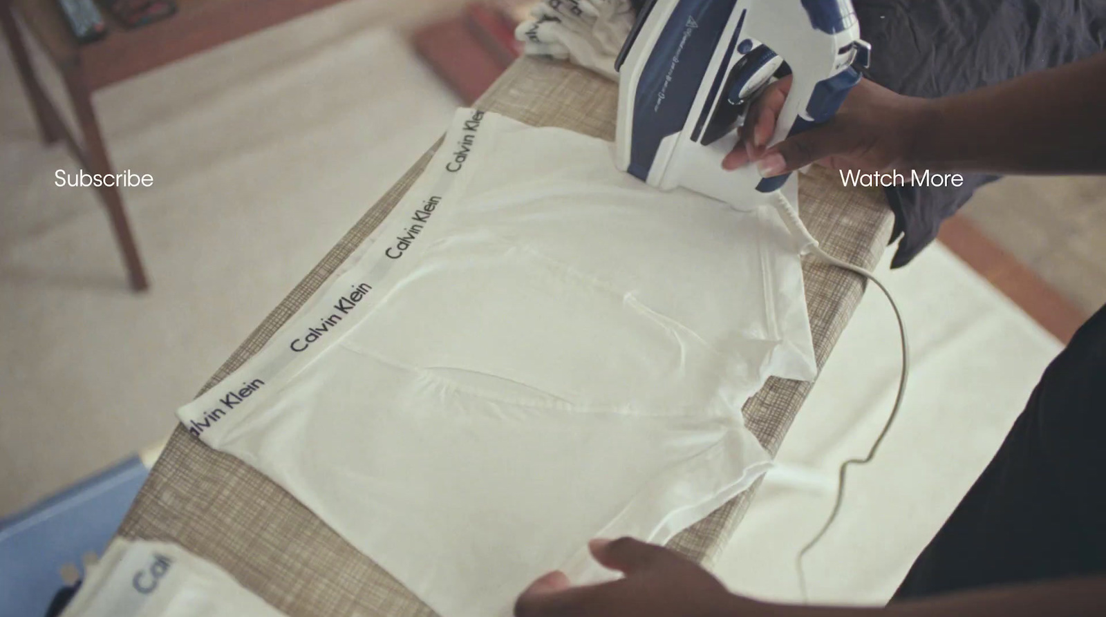 a person ironing a t - shirt on a table