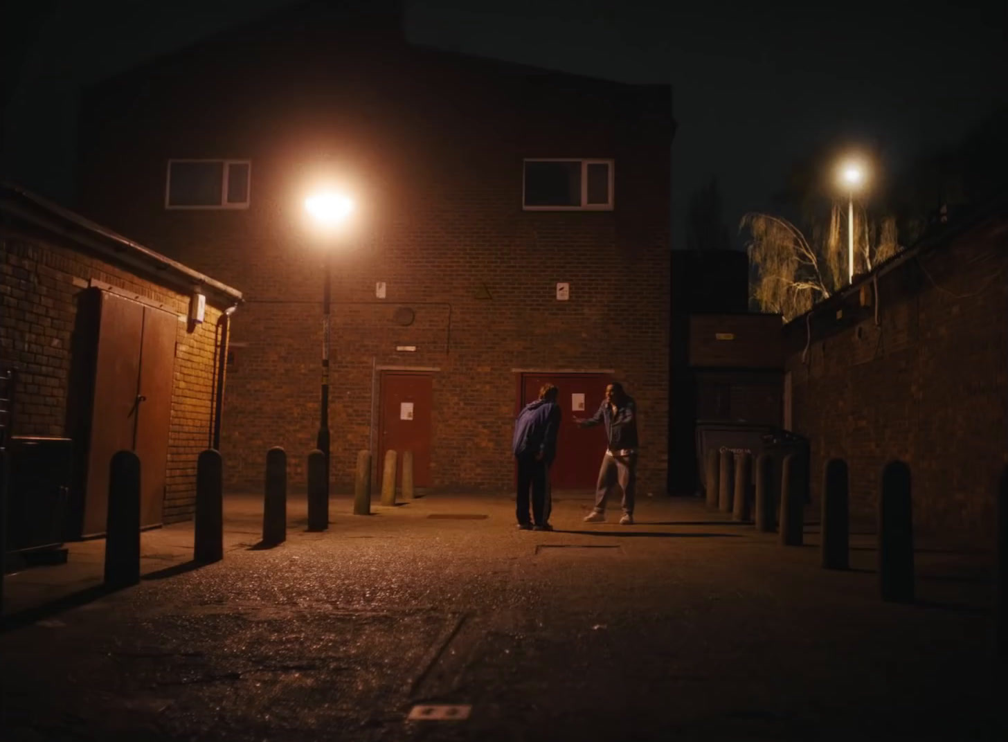 a couple of people walking down a street at night