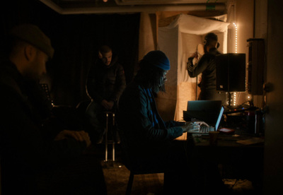 a group of people sitting around a laptop computer