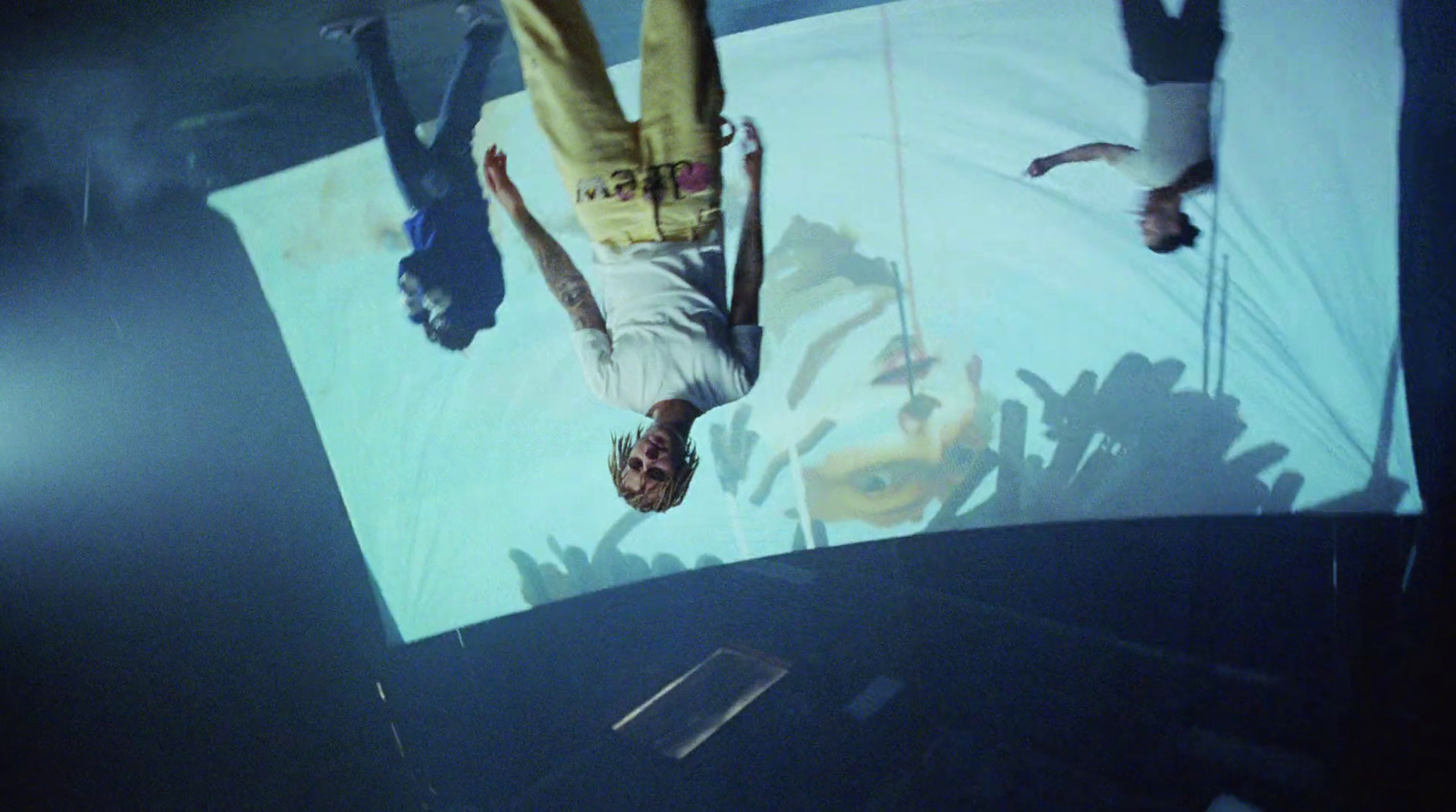 a man is upside down on a large screen