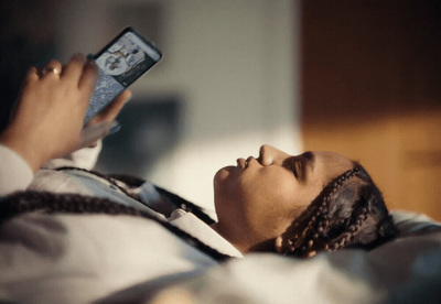 a woman laying in bed holding a cell phone