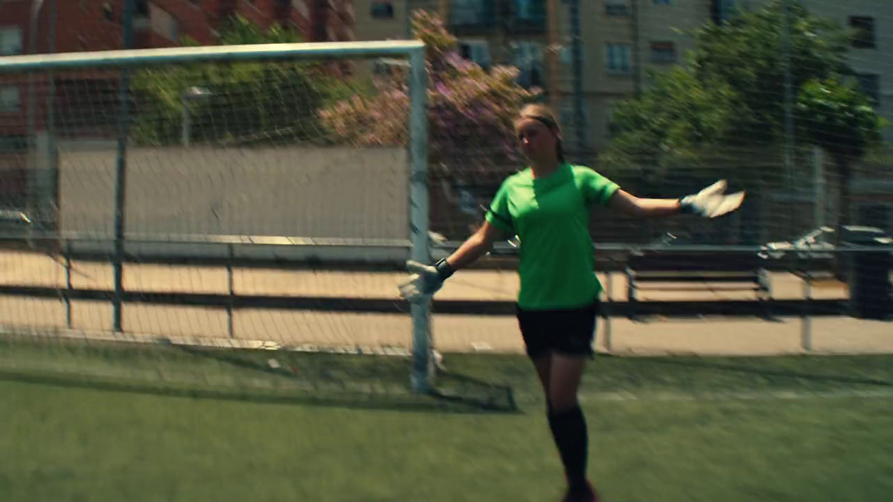 a woman in a green shirt is playing soccer