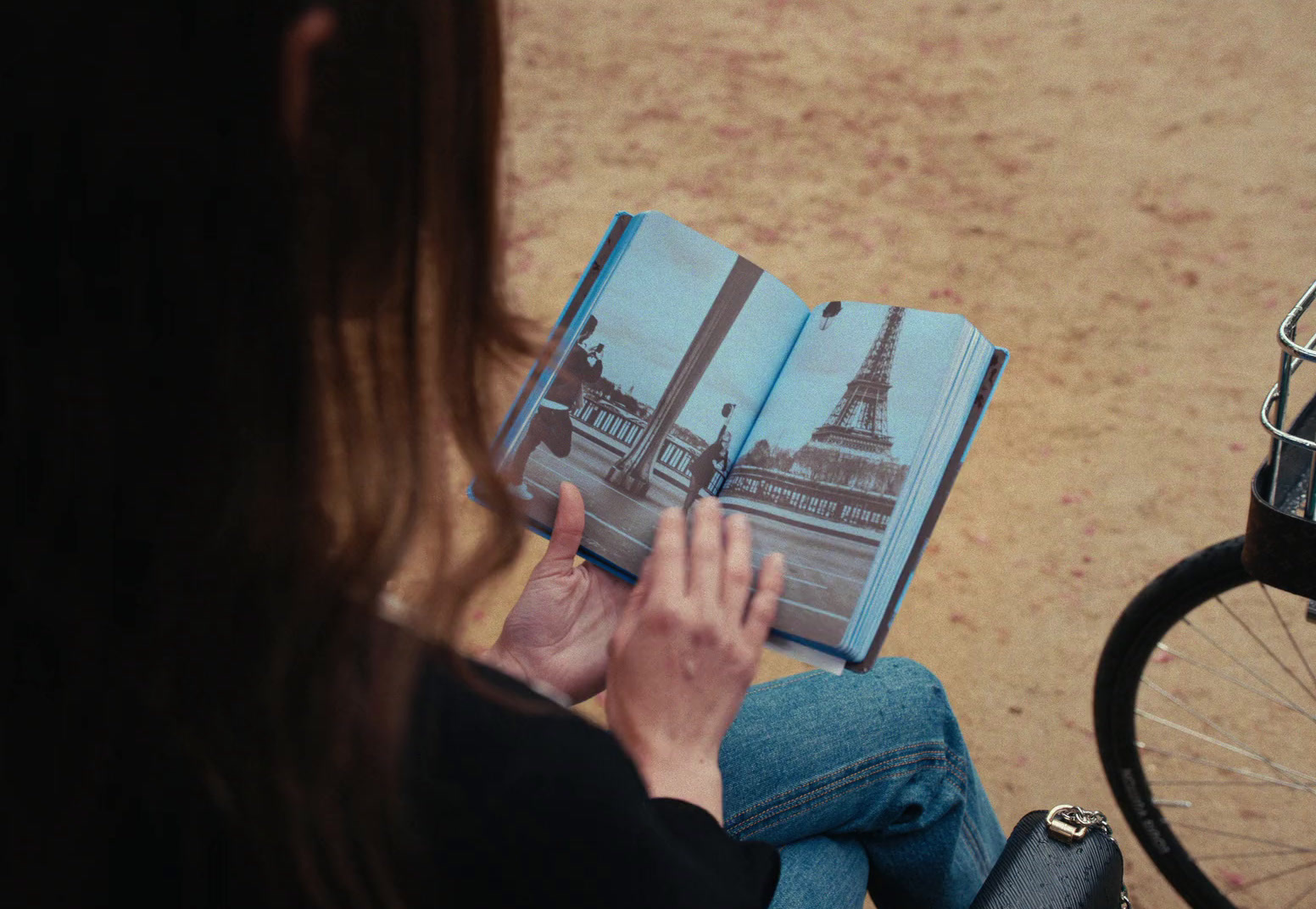 a woman sitting on the ground reading a book