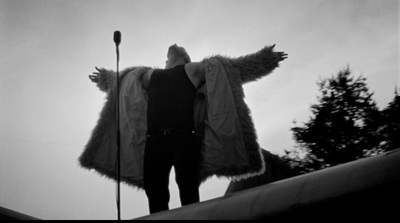 a man standing on top of a roof next to a microphone