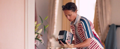 a woman in a striped dress holding a box