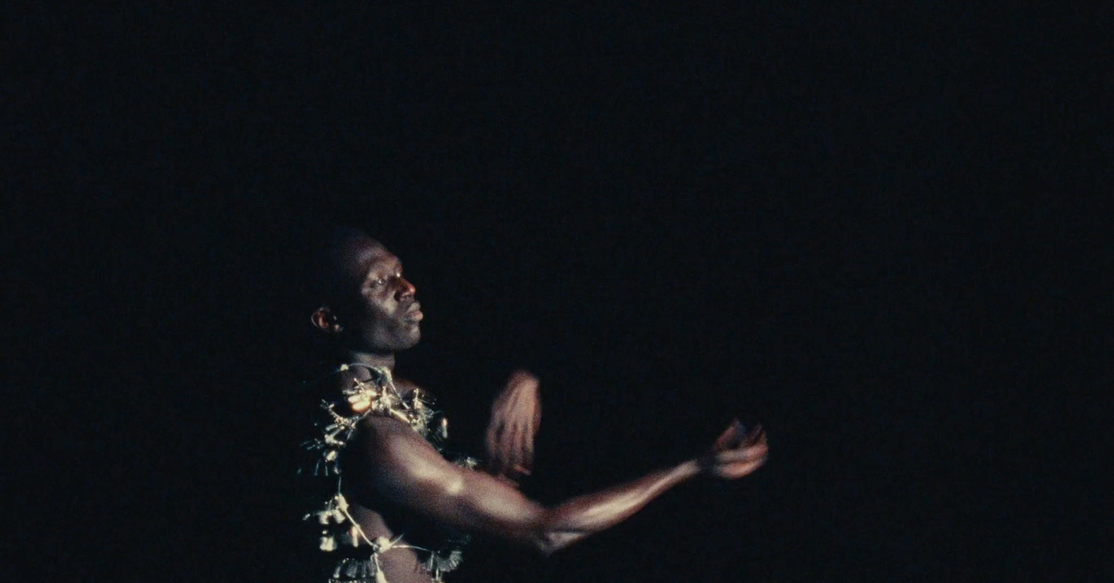 a man standing in the dark holding a frisbee