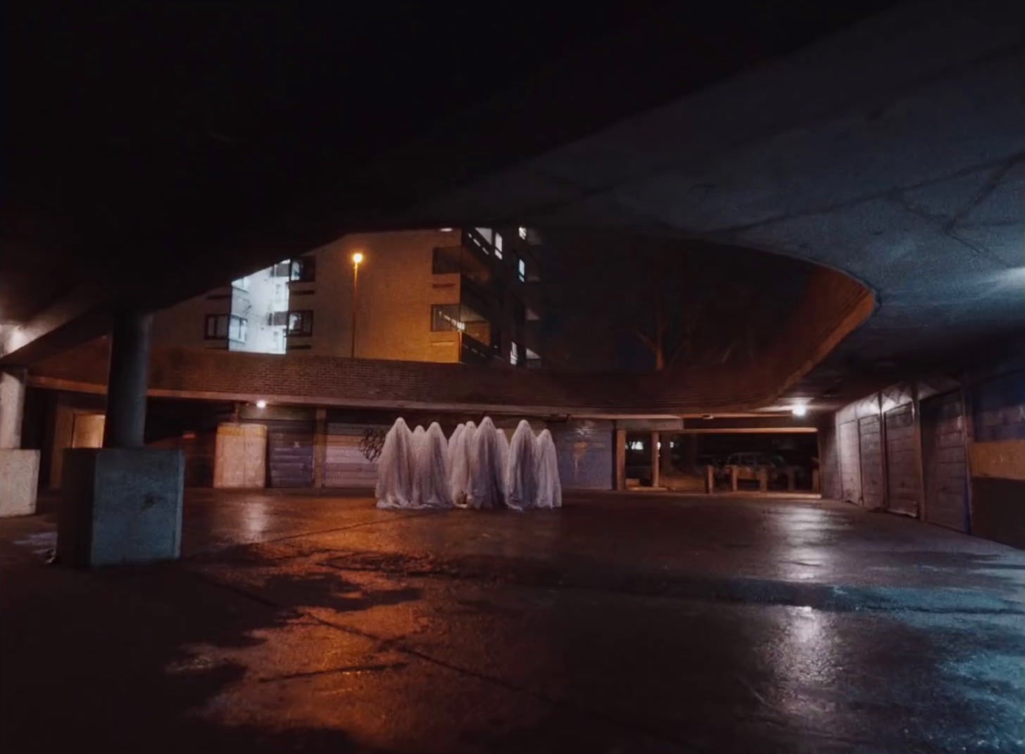 a parking garage with a row of white cloths hanging from the ceiling