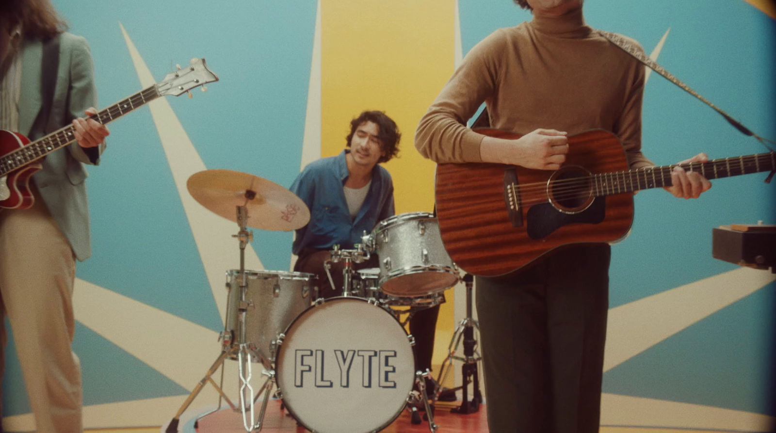 a group of people standing around a drum set