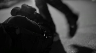 a black and white photo of a person's legs and shoes