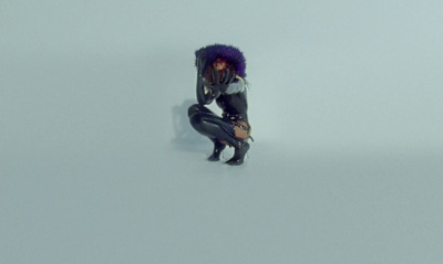 a woman with purple hair is kneeling down