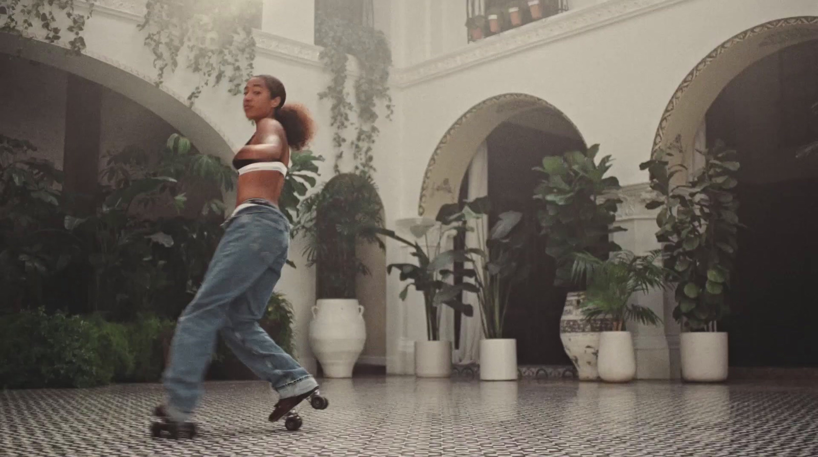 a woman in a white top is dancing in a courtyard