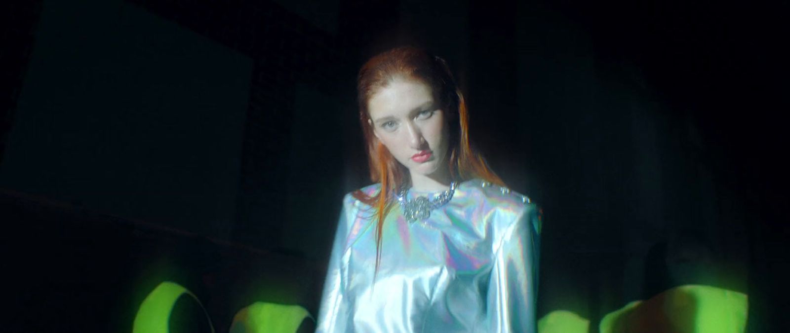 a woman with red hair in a shiny outfit