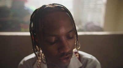 a man with dreadlocks and a white shirt