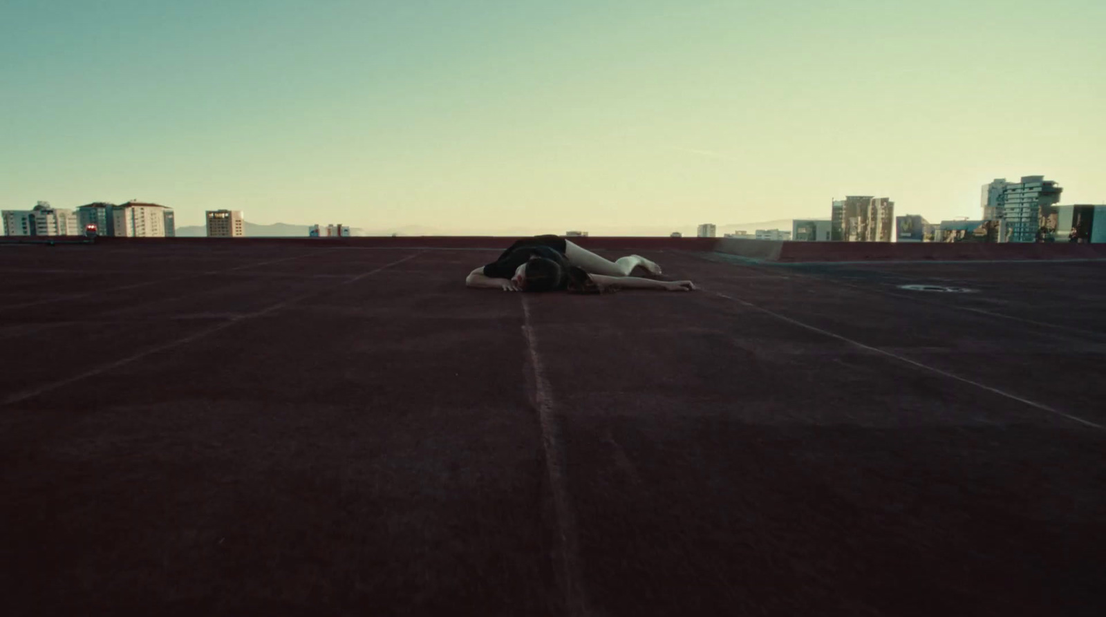 a person laying on the ground in a parking lot