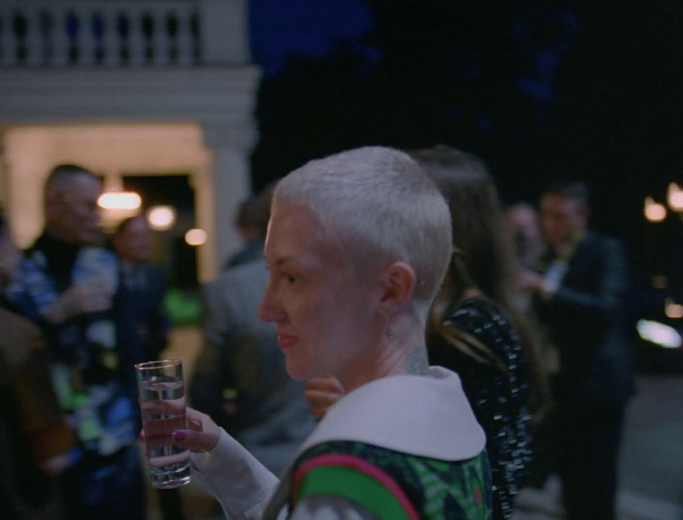 a woman with white hair holding a glass of wine