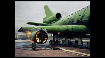 a large green jet sitting on top of a runway