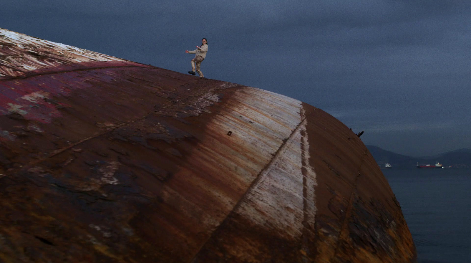 a man standing on top of a rusted metal structure