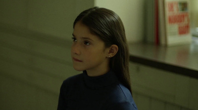 a young girl standing in front of a counter