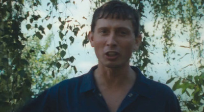 a man making a surprised face in front of a tree