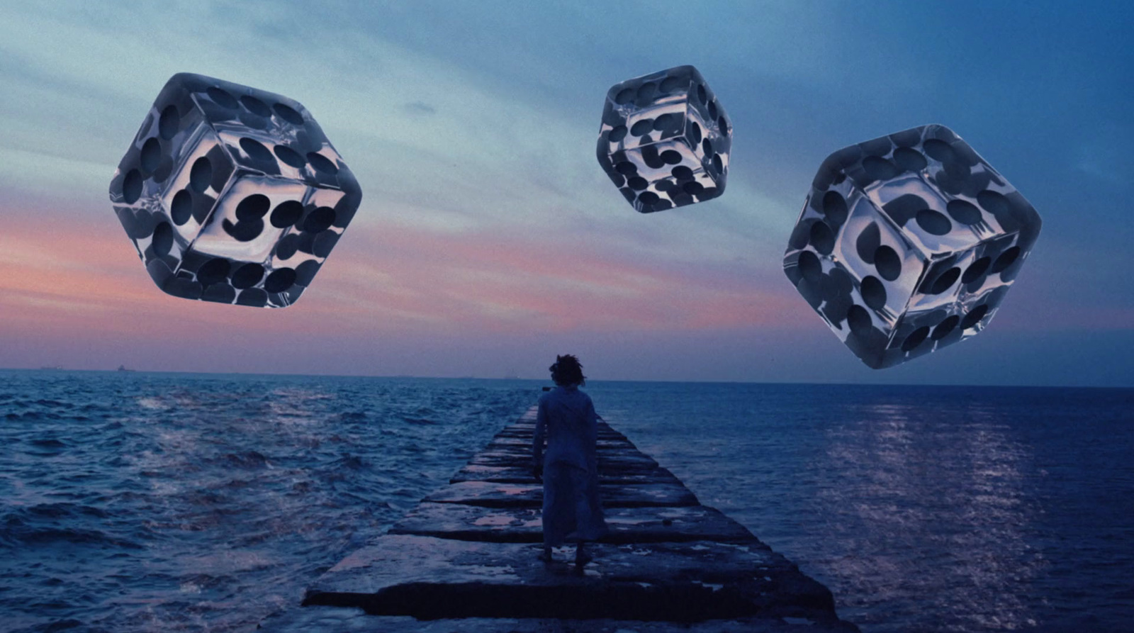 a person standing on a pier looking at the ocean