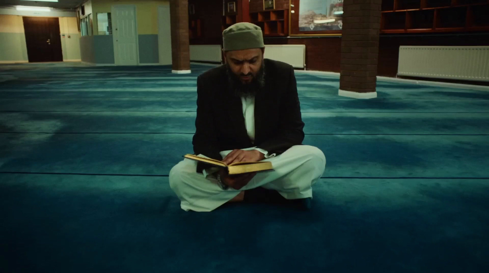 a man sitting on the floor reading a book