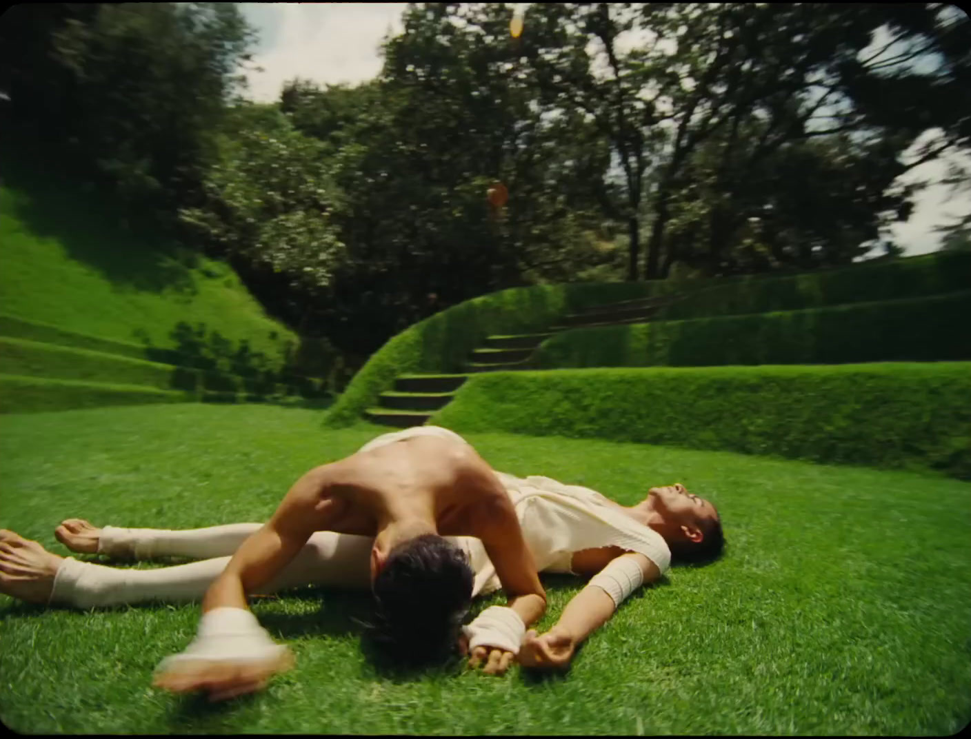 a man laying on top of a lush green field