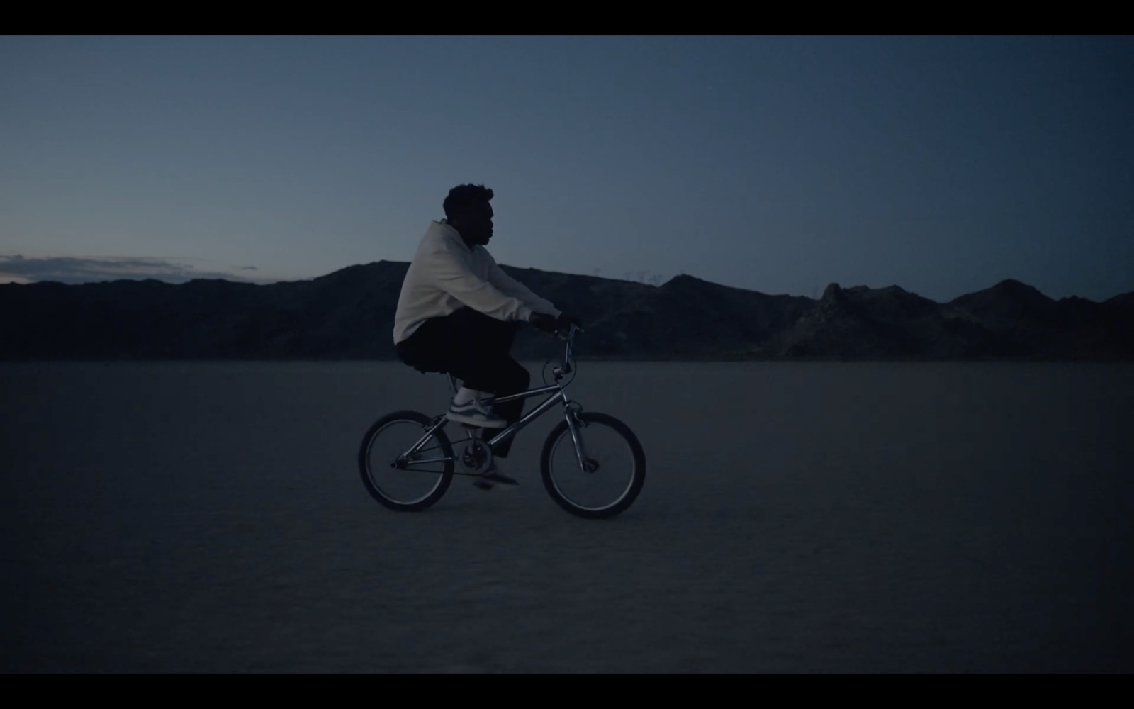 a man riding a bike in the middle of a desert