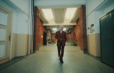 a man in a suit walking down a hallway