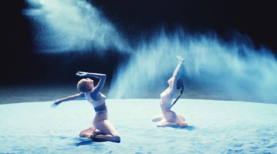 a couple of women standing on top of a snow covered ground