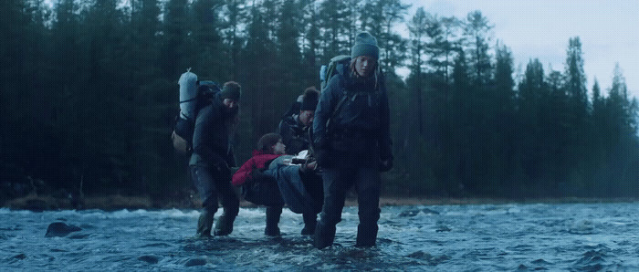 a group of people walking across a river