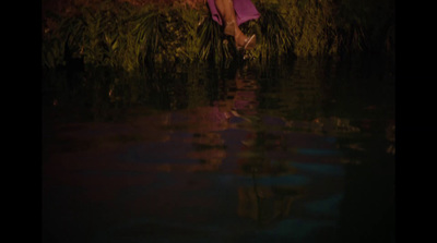 a woman in a purple dress standing in a body of water