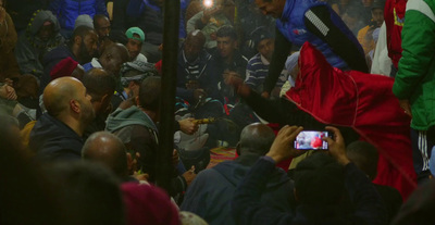 a crowd of people standing around a man holding a cell phone