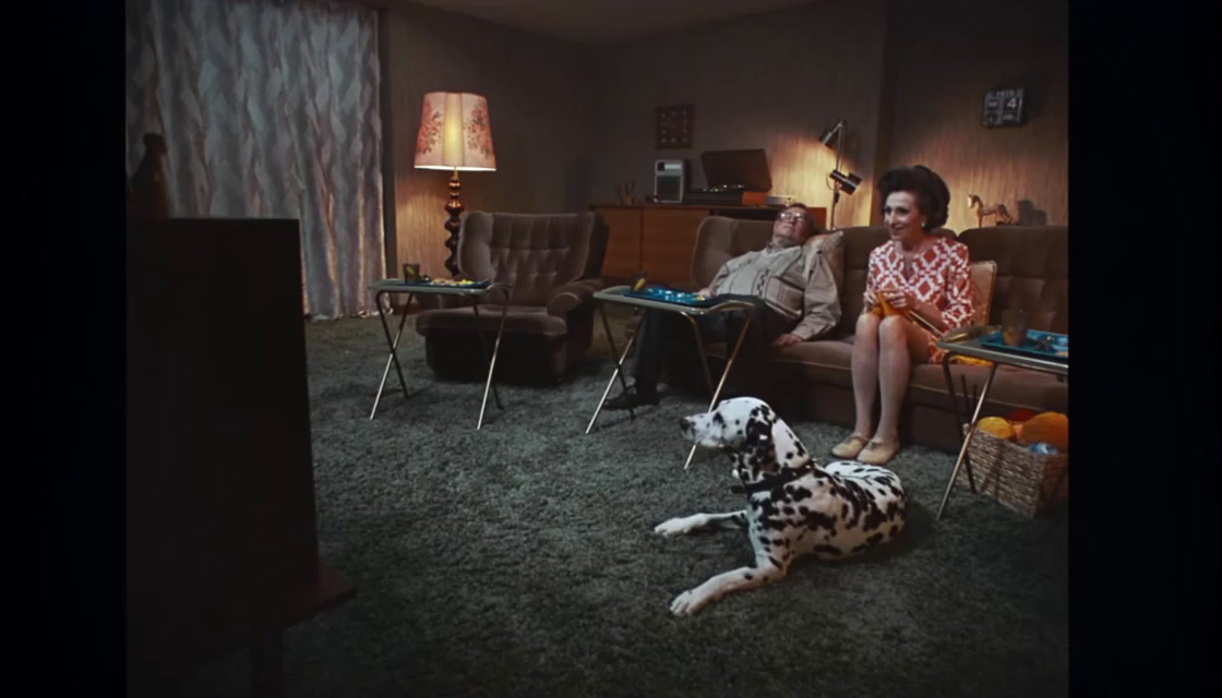 a woman sitting on a couch next to a dalmatian