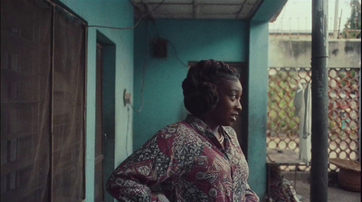 a woman standing outside of a blue building