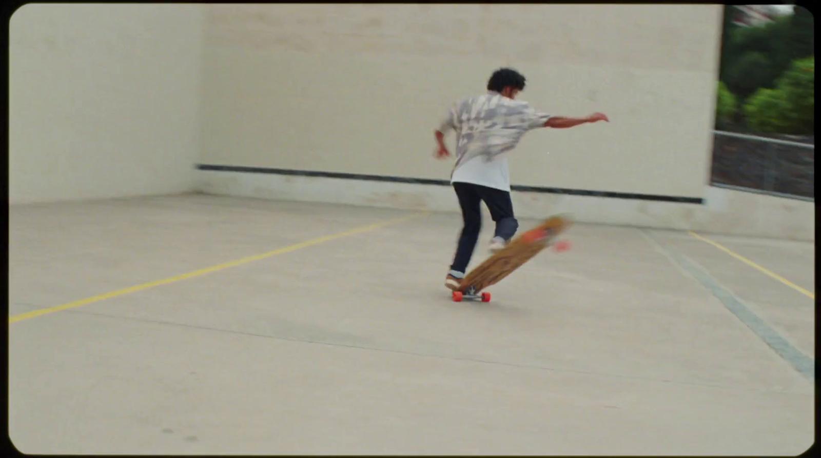 a man riding a skateboard across a parking lot