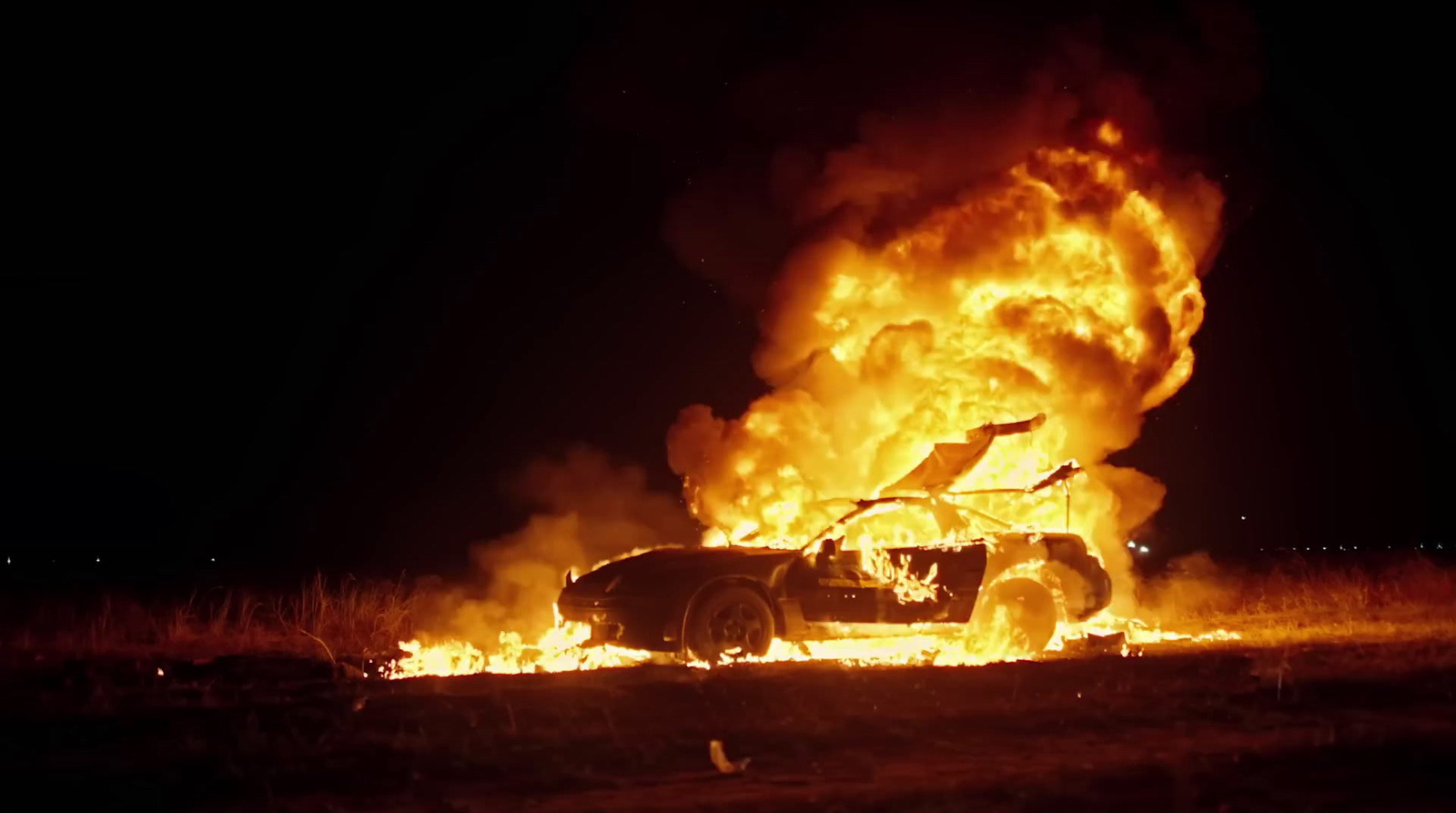 a car on fire in a field at night