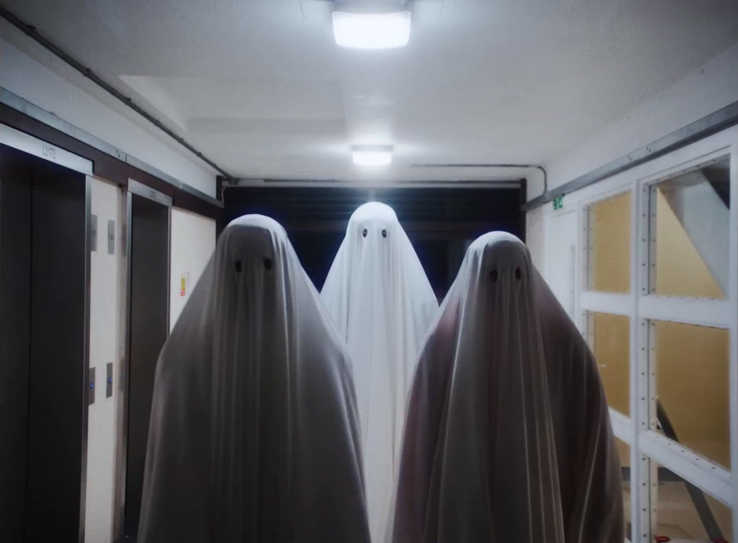 two ghostly people standing in front of a doorway