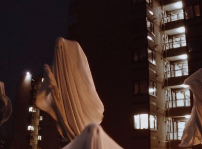 a statue of a woman in a white dress in front of a tall building