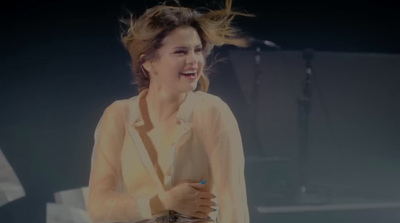 a woman standing on a stage holding a microphone