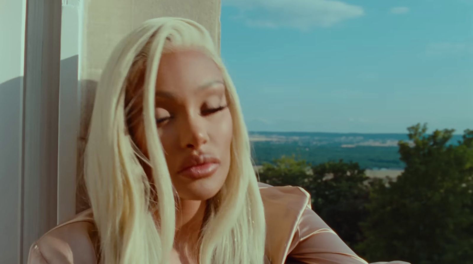 a woman with long blonde hair sitting on a window sill