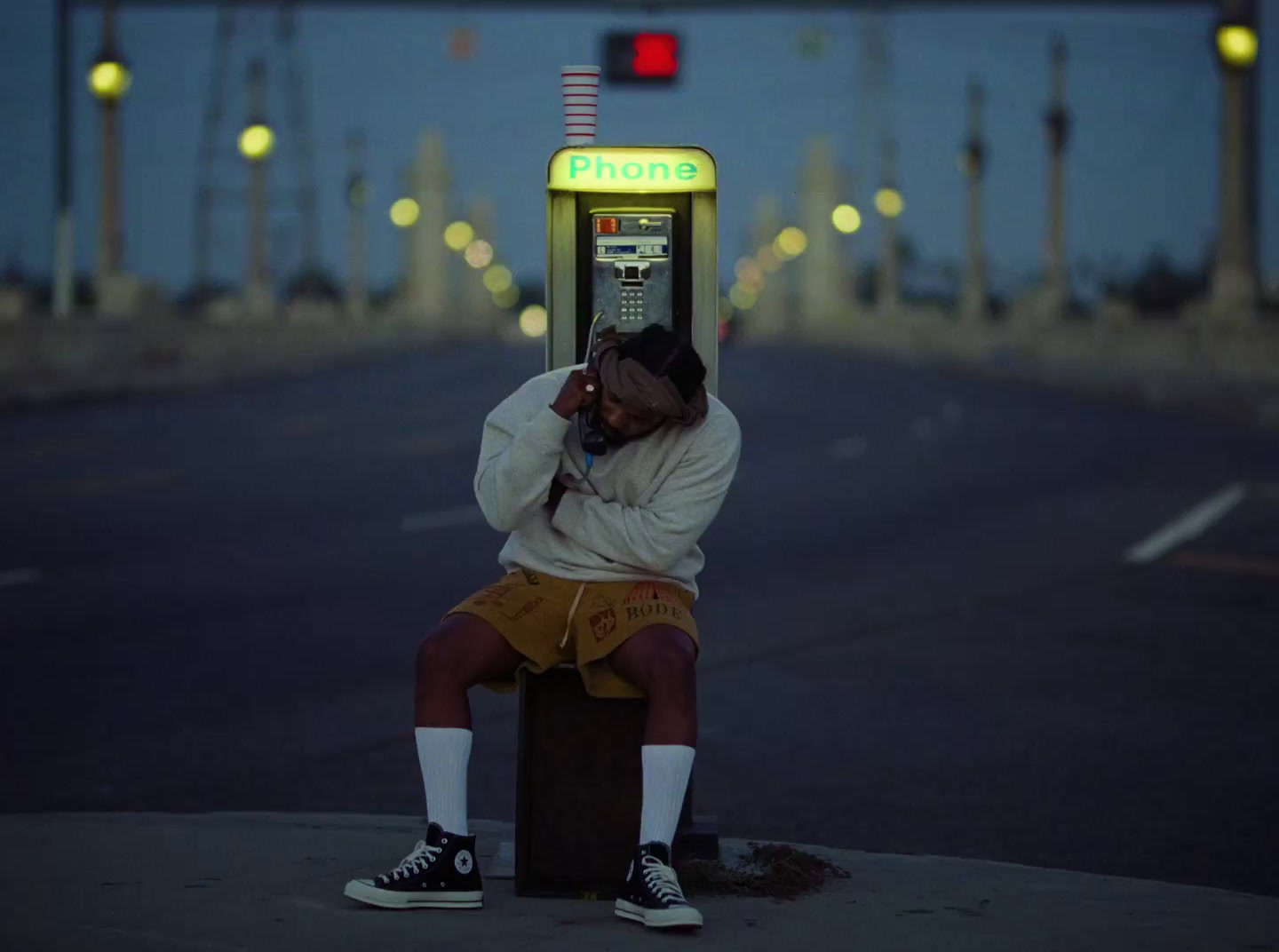 a man sitting on a box talking on a cell phone